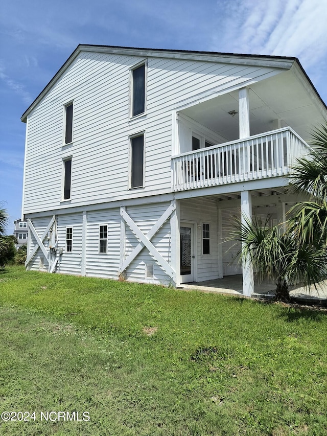 rear view of property featuring a lawn