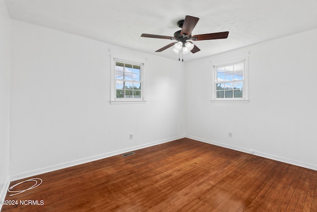 unfurnished room featuring a healthy amount of sunlight, ceiling fan, and hardwood / wood-style floors