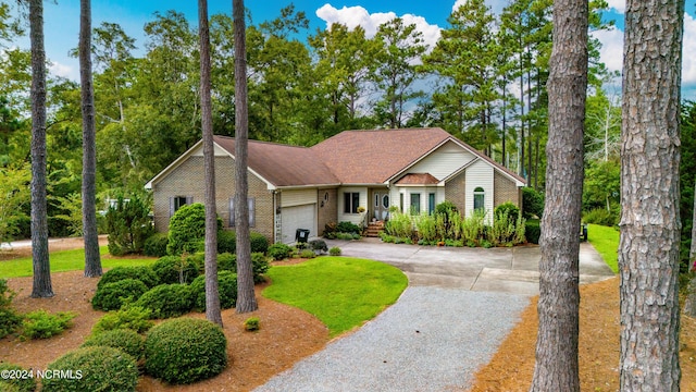 view of front facade with driveway, a garage, and brick siding
