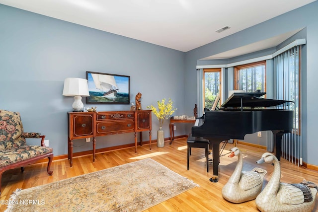 living area featuring baseboards, visible vents, and wood finished floors