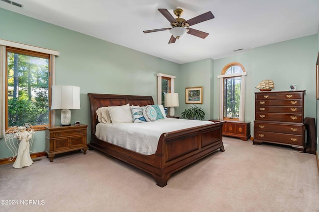 bedroom with light carpet, multiple windows, and visible vents