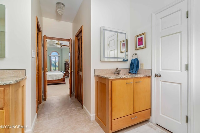 hallway with baseboards, a sink, and light tile patterned floors