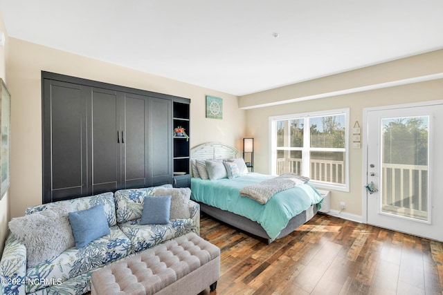 bedroom featuring access to exterior and dark wood-type flooring