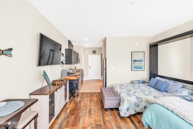 bedroom with stainless steel refrigerator, a closet, and dark hardwood / wood-style floors