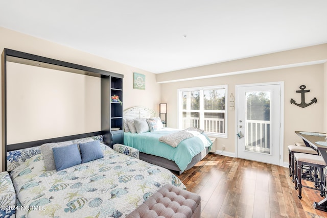 bedroom with hardwood / wood-style floors and access to exterior