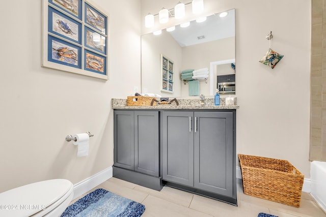 bathroom with a washtub, tile patterned floors, vanity, and toilet