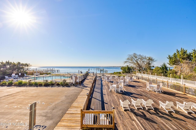 dock area featuring a water view and a community pool