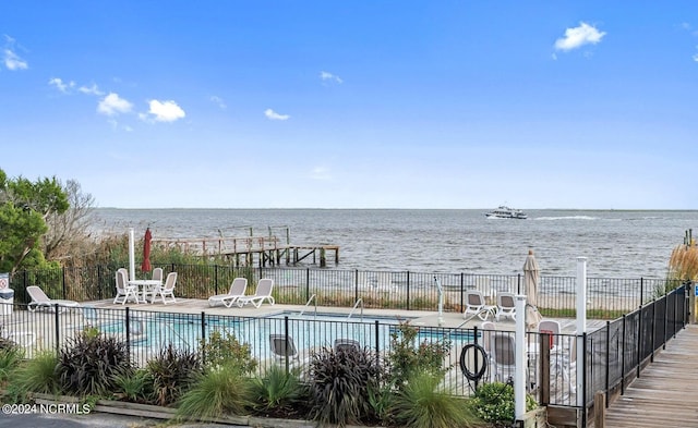 view of pool featuring a patio and a water view