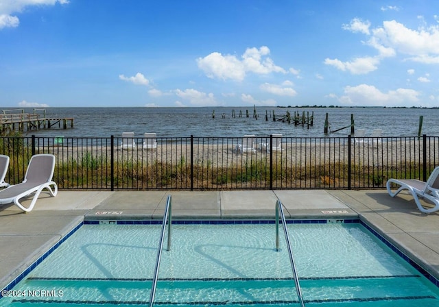 view of swimming pool featuring a patio area and a water view