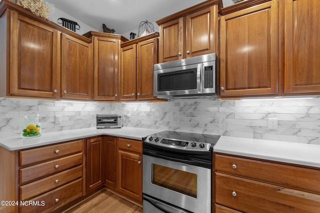 kitchen featuring light hardwood / wood-style flooring, tasteful backsplash, and stainless steel appliances