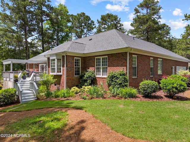 single story home featuring a deck and a front lawn