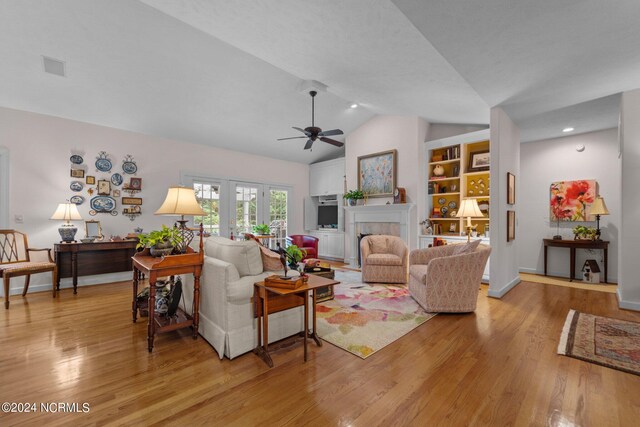 living room featuring vaulted ceiling, light wood-type flooring, and ceiling fan