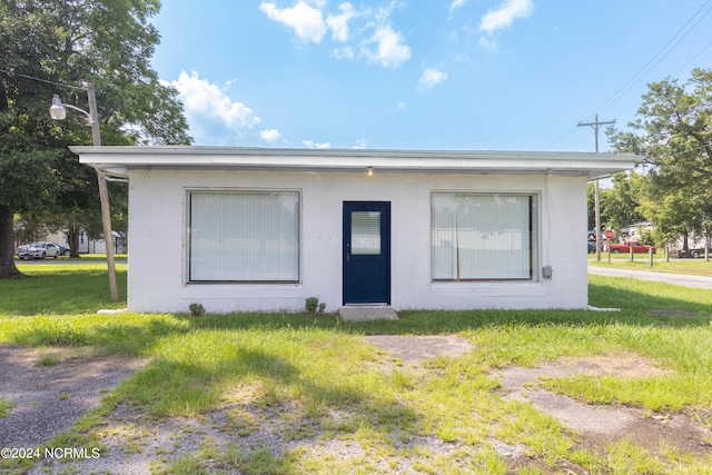 bungalow featuring a front lawn