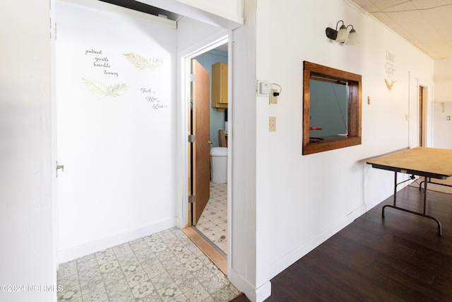 hall featuring light floors and baseboards