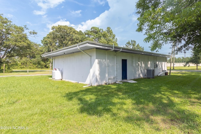 exterior space featuring cooling unit and a yard