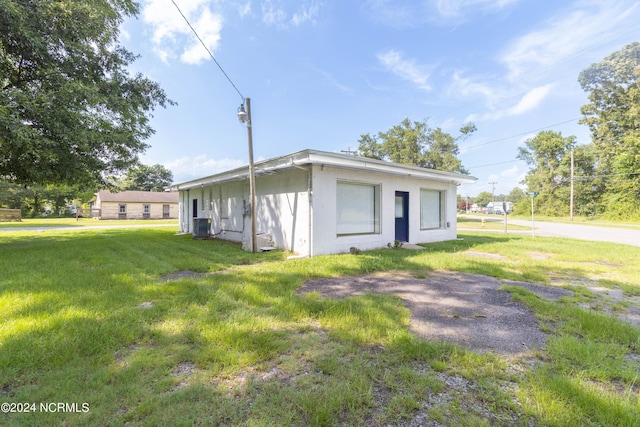 view of front of home featuring a front yard and central air condition unit