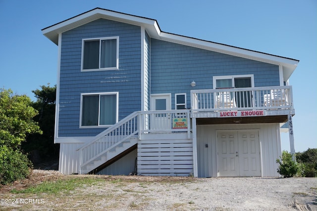 back of house featuring stairway and a deck