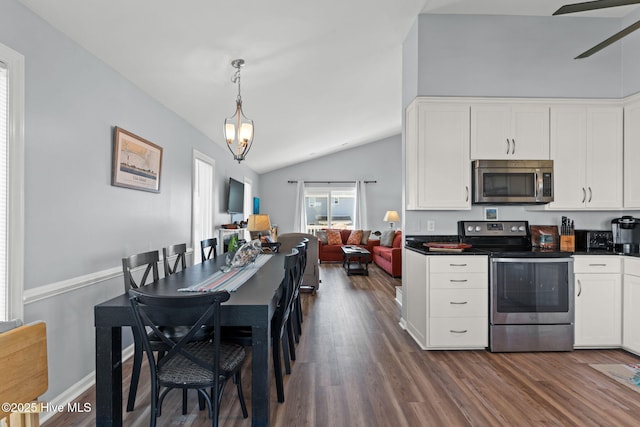 kitchen featuring dark wood-style flooring, dark countertops, white cabinetry, lofted ceiling, and appliances with stainless steel finishes