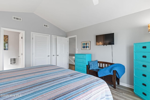 bedroom featuring baseboards, lofted ceiling, visible vents, and light wood-type flooring