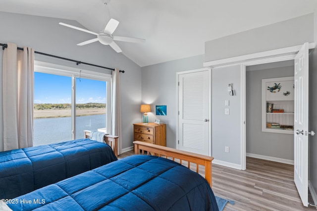 bedroom with vaulted ceiling, a ceiling fan, baseboards, and light wood-type flooring