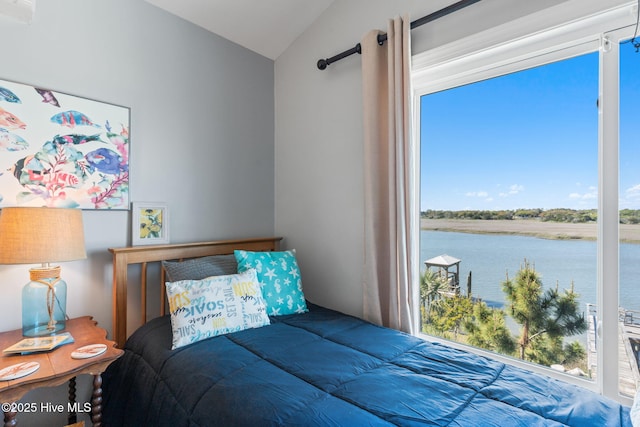 bedroom with lofted ceiling, a water view, and multiple windows