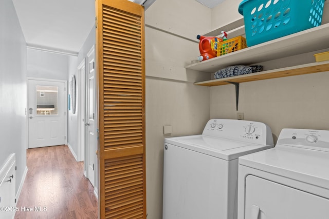 washroom featuring washing machine and clothes dryer, light wood-style floors, and laundry area