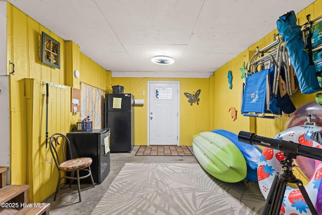 interior space featuring concrete floors and wooden walls