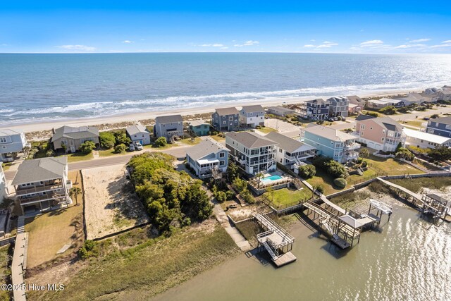 birds eye view of property featuring a beach view and a water view