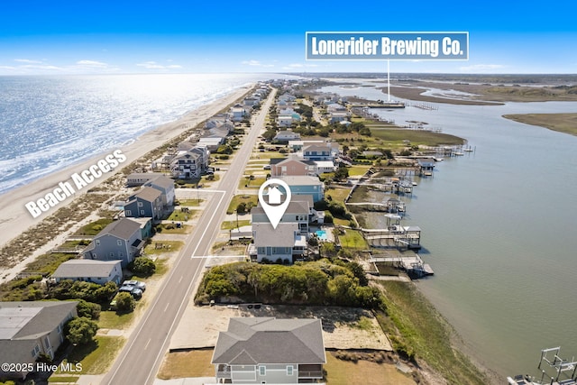 aerial view with a view of the beach, a water view, and a residential view