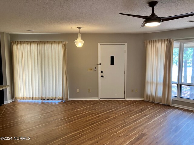 unfurnished room featuring a textured ceiling, ceiling fan, and hardwood / wood-style flooring