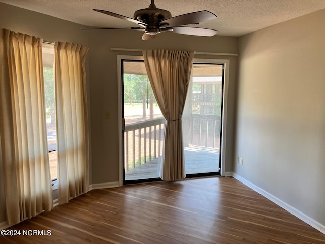 interior space with ceiling fan, baseboards, a textured ceiling, and dark wood-style floors