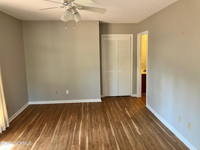 unfurnished bedroom featuring ceiling fan, wood finished floors, a closet, and baseboards