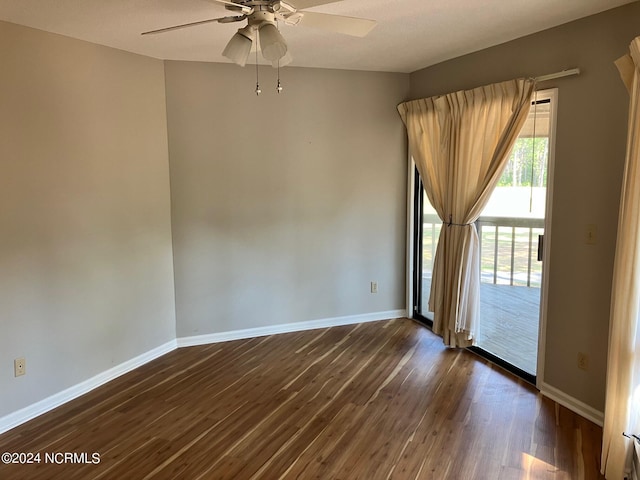 unfurnished room featuring ceiling fan, dark wood-type flooring, and baseboards