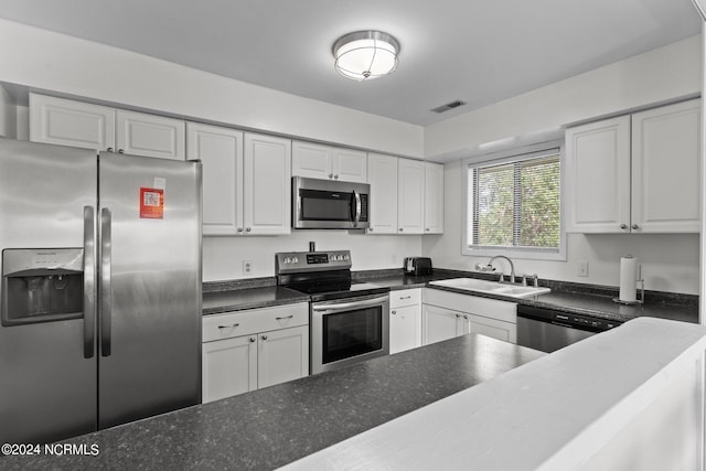 kitchen featuring appliances with stainless steel finishes, visible vents, a sink, and white cabinetry