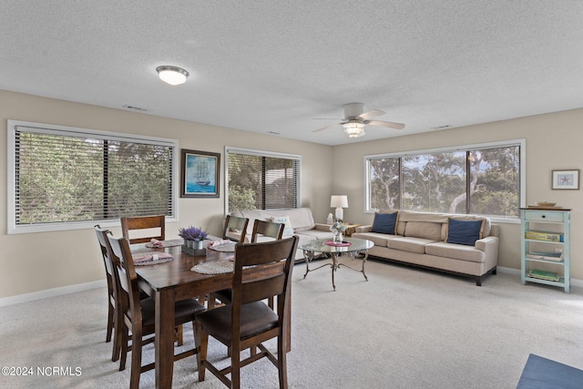 dining room featuring visible vents, carpet, a wealth of natural light, and baseboards