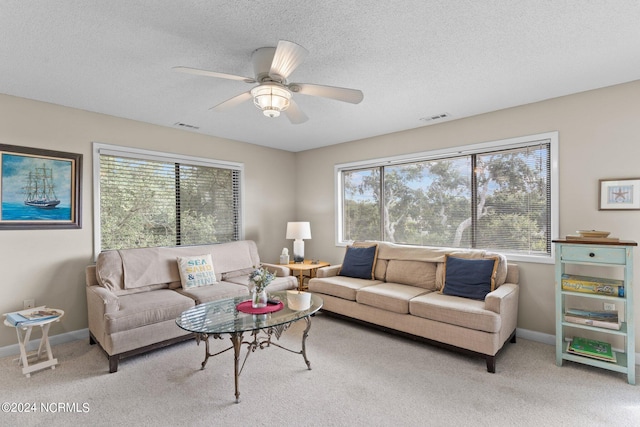 living area with visible vents, carpet flooring, ceiling fan, a textured ceiling, and baseboards