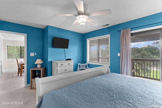 bedroom with carpet, access to outside, visible vents, and a textured ceiling