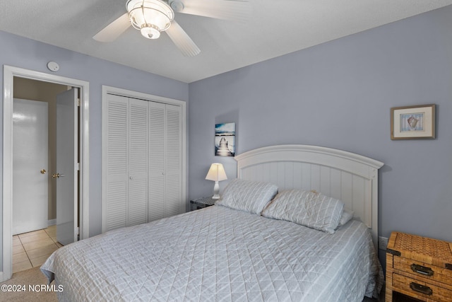 bedroom with a ceiling fan, tile patterned flooring, and a closet