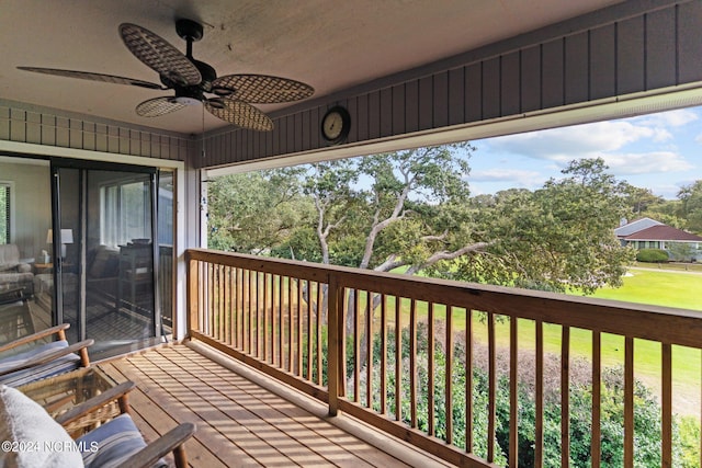 wooden deck featuring a ceiling fan and a yard