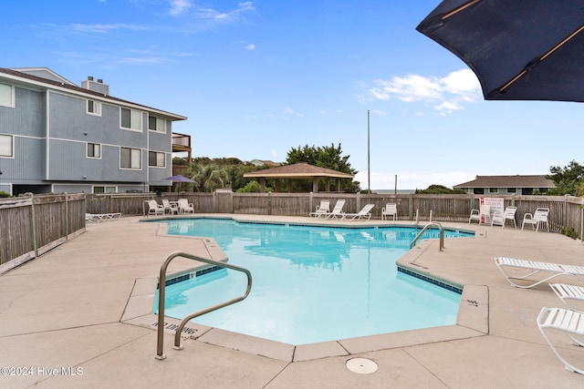 community pool with a patio area and fence