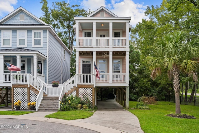 beach home featuring a carport, a porch, and a front yard