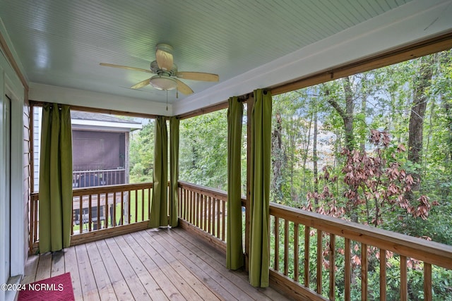 unfurnished sunroom with plenty of natural light and a ceiling fan