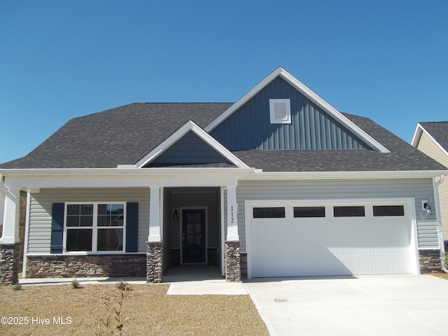 craftsman-style house with stone siding, roof with shingles, board and batten siding, concrete driveway, and an attached garage