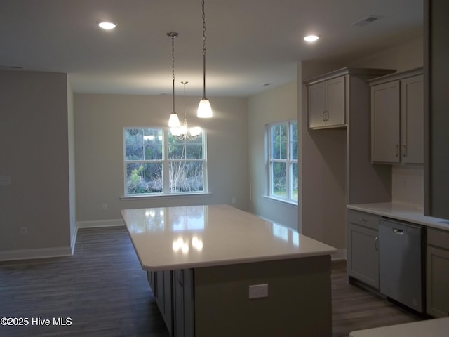 kitchen featuring dishwasher, a center island, dark wood-style flooring, and light countertops