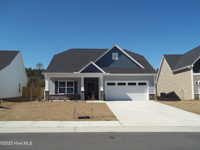 craftsman house featuring stone siding, board and batten siding, an attached garage, and concrete driveway