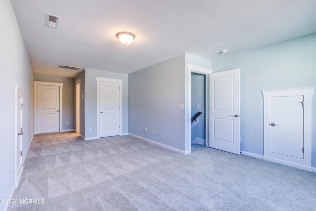 unfurnished bedroom featuring visible vents, baseboards, and carpet