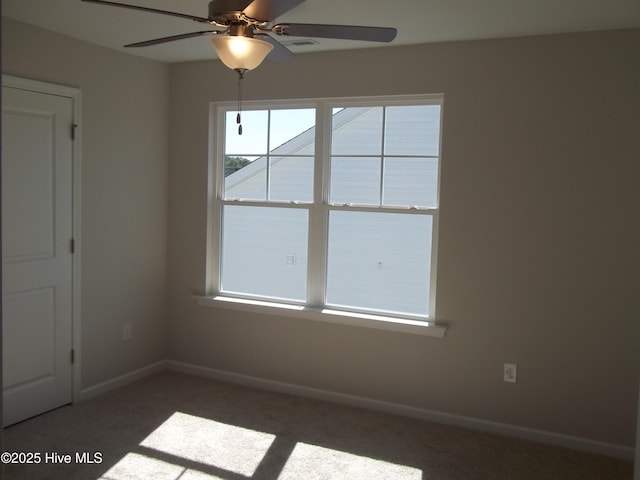 empty room featuring a ceiling fan, baseboards, and carpet floors