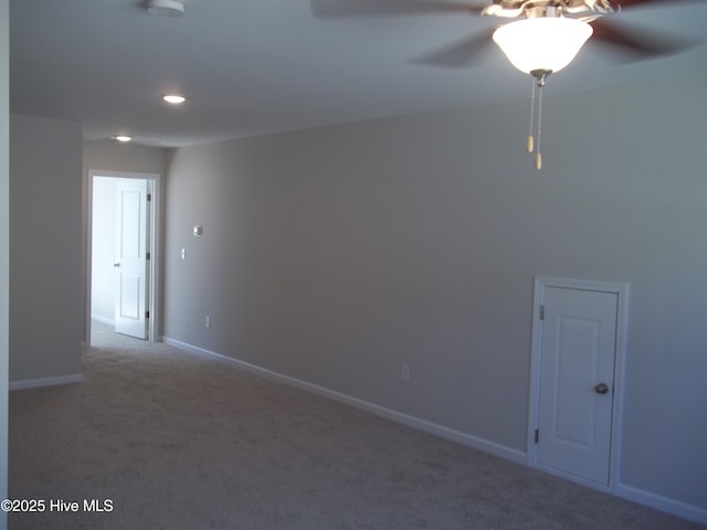 spare room featuring carpet flooring, baseboards, and ceiling fan