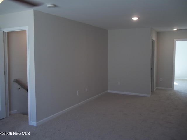 unfurnished room with light carpet and baseboards