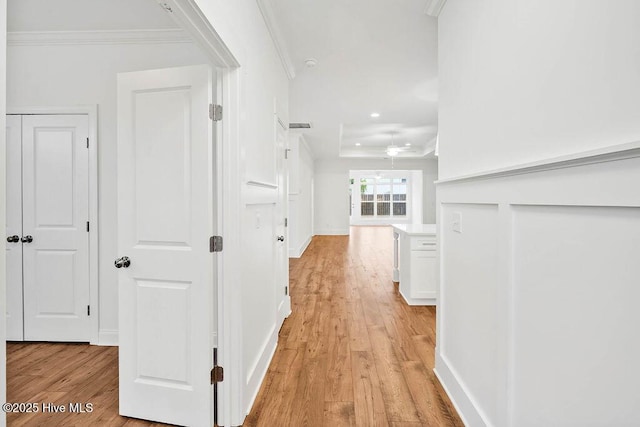 hallway featuring crown molding and light hardwood / wood-style floors